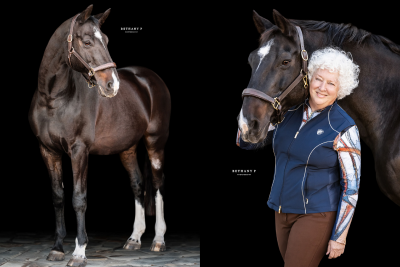 Horse and owner standing beside each other with a back background.